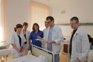 Poranny obchód, lekarze i studenci kierunku Lekarskiego przy łóżku pacjenta.