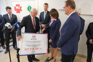 Symboliczny czek na 228 mln zł dla UDSK wręcza wiceminister zdrowia Waldemar Kraska 